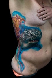 Great White Shark and Jelly Fish Tattoo with Bright blue  back ground, from armpit to hip with black background, done at the