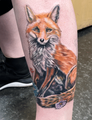 Fox tattoo sitting on the of calf,  inked at Art In Motion tattoos in Colorado springs