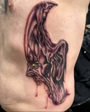 Abstract Vampire head on rib cage colored red with blooded saliva, done at art in motion tattoo studio.