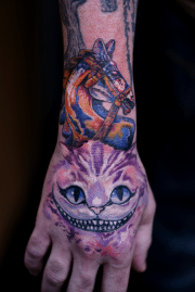 Cheshire cat tattoo on hand with knight piece on top, full color, art in motion tattoo shop.