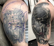 Spartan cover-up tattoo of a lion on arm, done in black and gray with some color aspects, colorado springs tattoo shop.