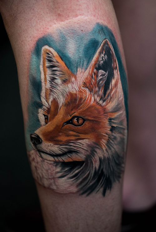 A Artic Fox Tattoo that is going from summer to winter coat. Half white half Orange Red