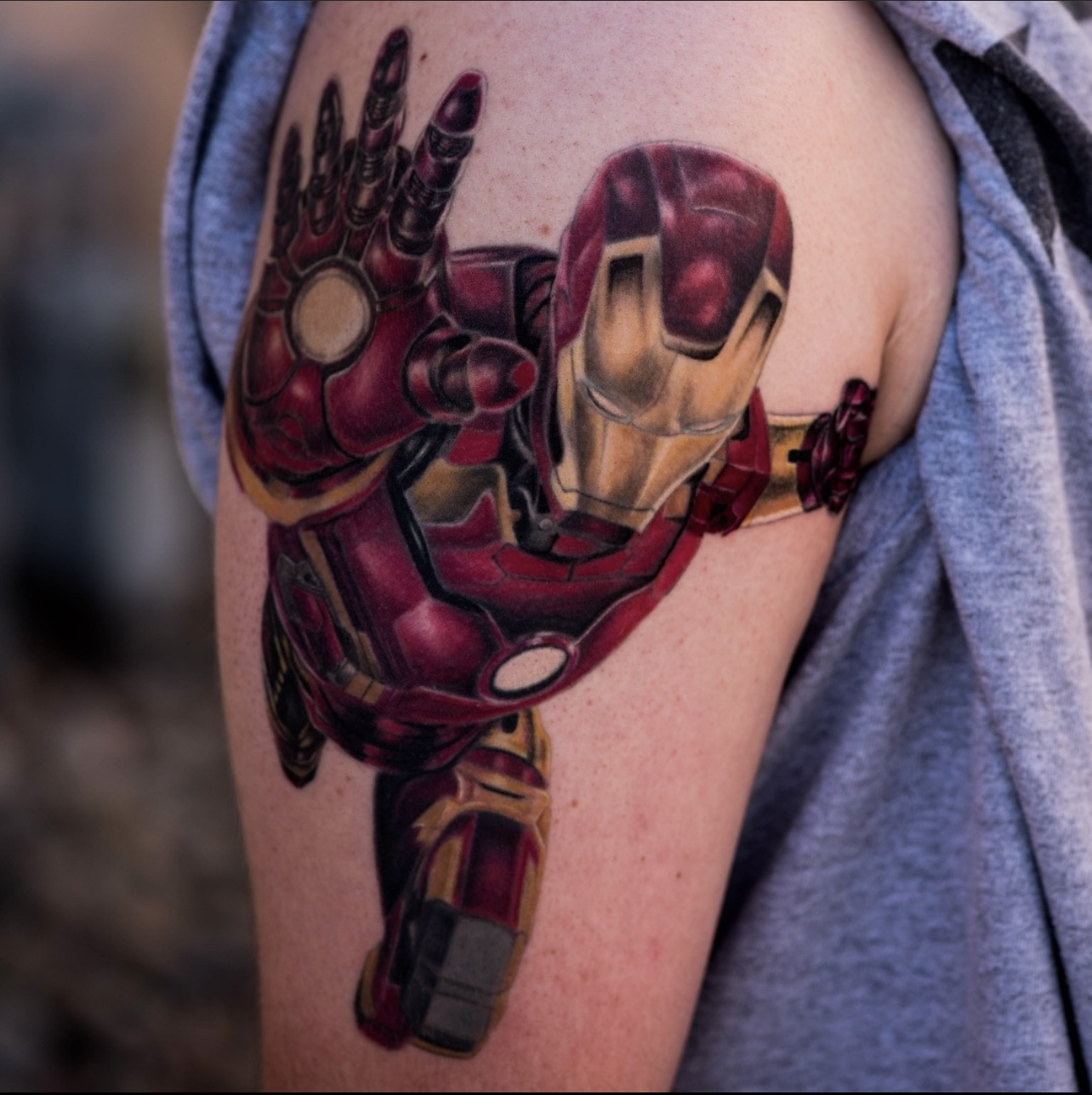 Realistic iron man tattoo on the right upper arm, created by tattoo artists at art in motion.