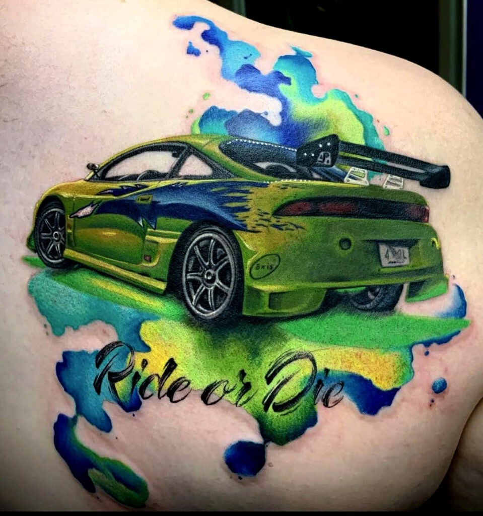 a colorful green and blue car tattoo with water color elements with font that says ride or die done in colorado springs tattoo shop.